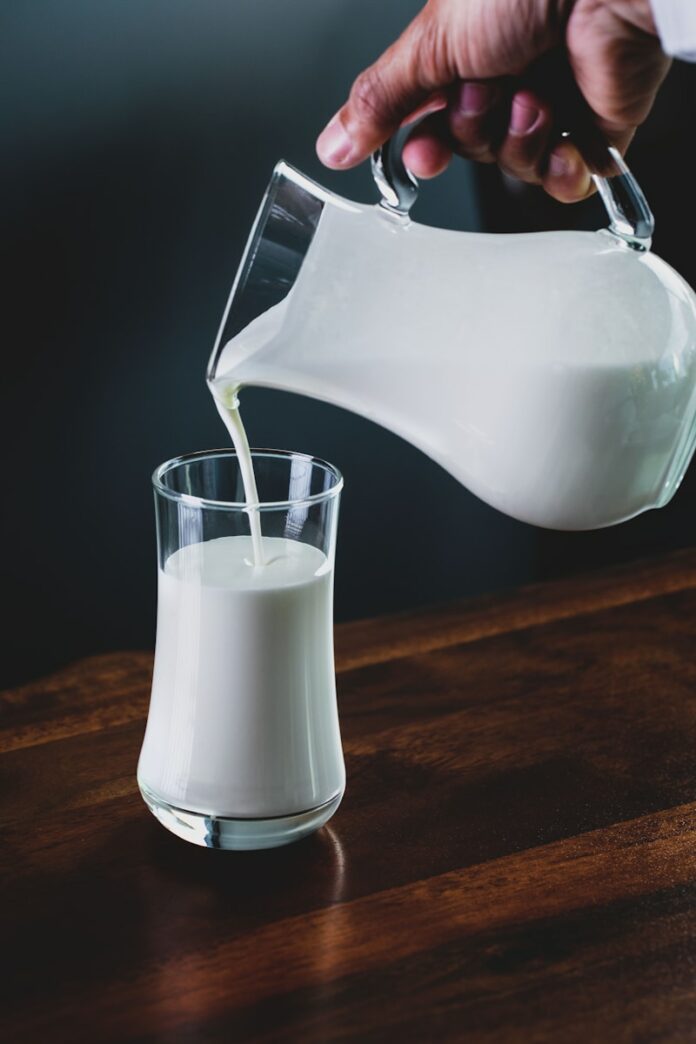 Photo by Eiliv Aceron person pours milk into glass