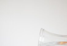 여름철 운동 중 더위를 피하는 방법 A pitcher pouring water into a glass filled with orange slices