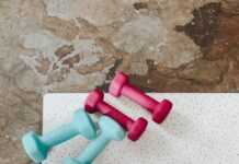 피트니스 목표 설정: 달성을 위한 전략과 방법 person holding white liquid filled cup above two pairs of dumbbells