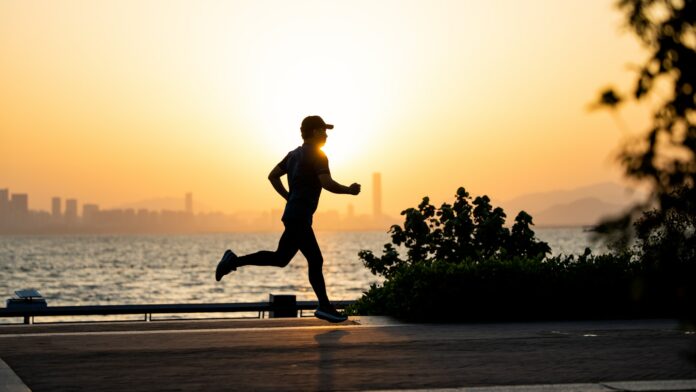 Photo by Shengpengpeng Cai a man running on the beach at sunset