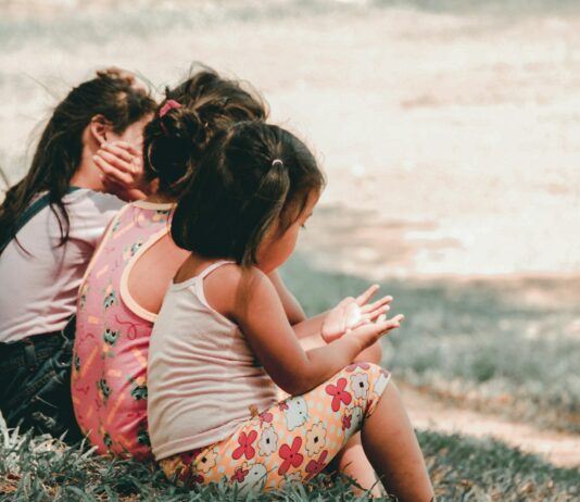 “우리 아이들의 권리를 지켜요” three children sitting on grass