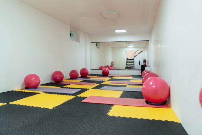 a room with exercise mats and exercise balls on the floor