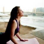 바디 리커버리: 근육의 ‘쉼표’가 만드는 완벽한 느낌표 woman in black tank top sitting on concrete floor during daytime