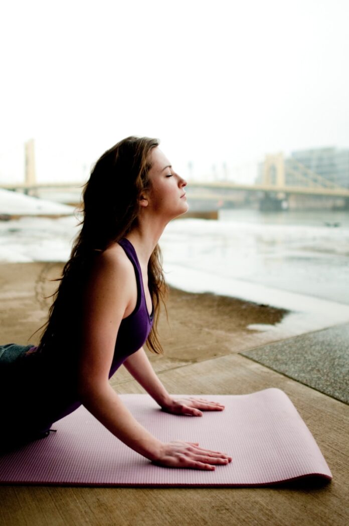 Photo by Katherine Hanlon woman in black tank top sitting on concrete floor during daytime