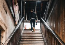 “근육 관리도 일상 속 작은 루틴에서부터”… 건강 트렌드로 떠오른 ‘생활 근력 챙기기’ A person walks up a wooden staircase.