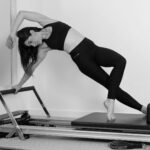 “오운완” 너머의 가치: MZ세대가 단순 웨이트보다 필라테스에 열광하는 진짜 이유 woman in black sports bra and black leggings doing yoga