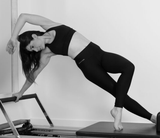 “오운완” 너머의 가치: MZ세대가 단순 웨이트보다 필라테스에 열광하는 진짜 이유 woman in black sports bra and black leggings doing yoga