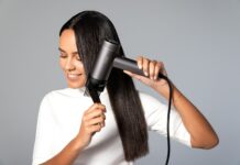 ‘건강한 두피와 윤기나는 모발’…일상 속 실천하는 헤어 루틴이 인기 a woman blow drying her hair with a hair dryer