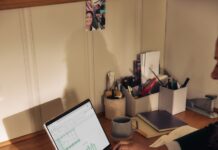 “마음도 챙기는 시대, 디지털 디톡스가 불러온 건강 습관 변화” Person working on laptop at a wooden desk.