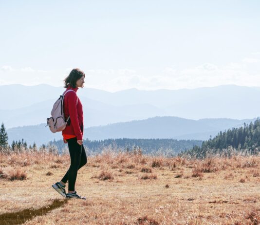 직장인 건강 지키는 ‘걷기 챌린지’, 일상 속 움직임으로 활력 UP a man with a backpack walking across a dry grass covered field